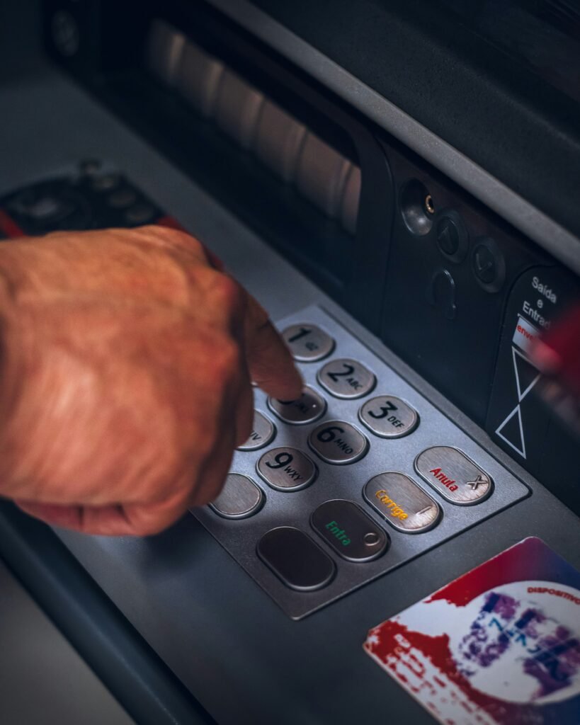 hand using an ATM pressing buttons

